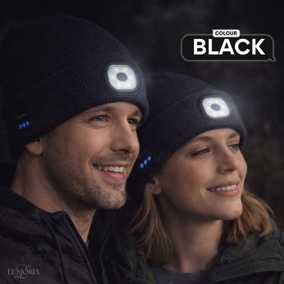 Man and woman wearing the GlowSound Beanie™ in black with Bluetooth audio and front LED light for outdoor use