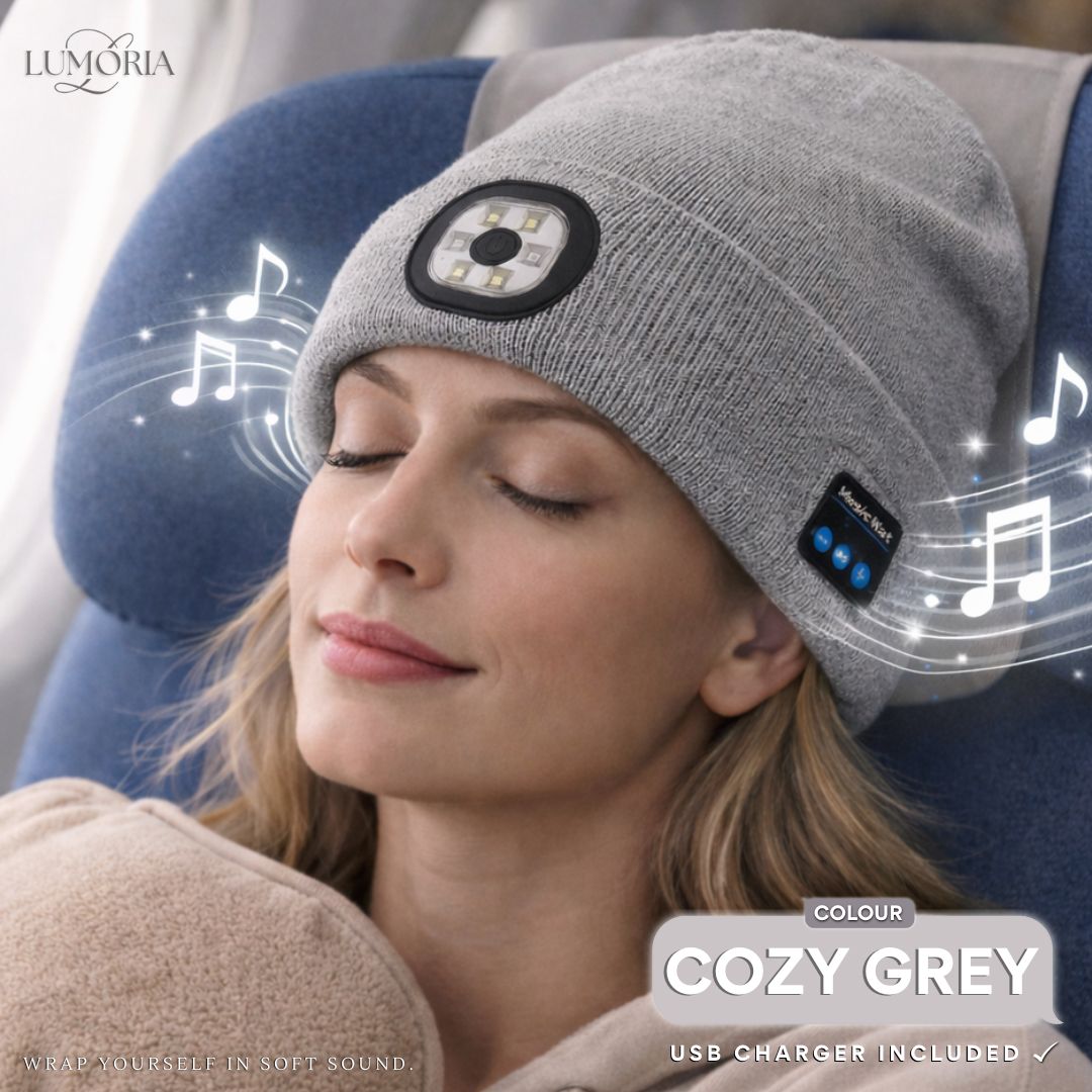 Woman wearing the GlowSound Beanie™ in cozy grey while relaxing, with Bluetooth music playback and integrated LED light