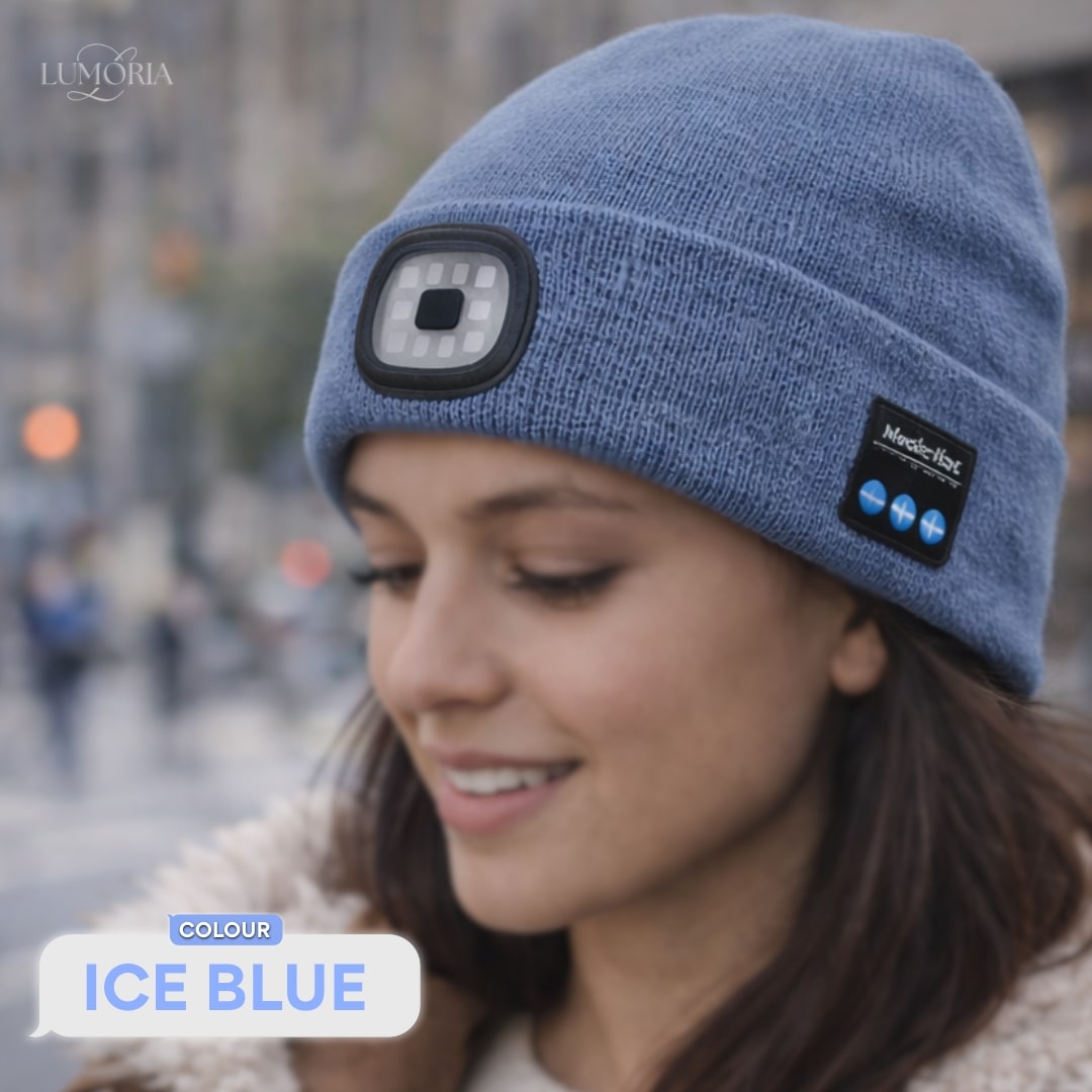 Woman wearing the GlowSound Beanie™ in ice blue with Bluetooth audio controls and a front LED light during everyday wear